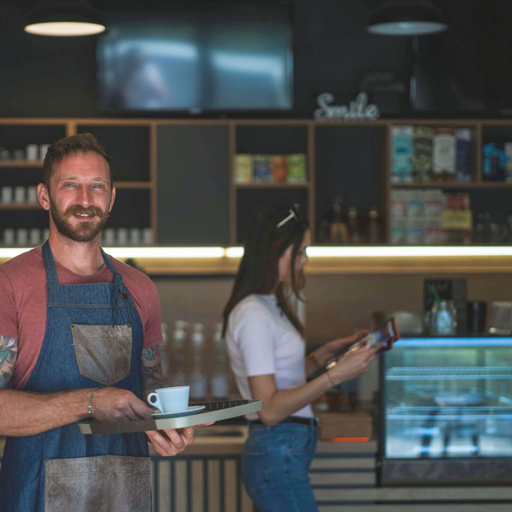 Happy cafe owner behind checkout counter